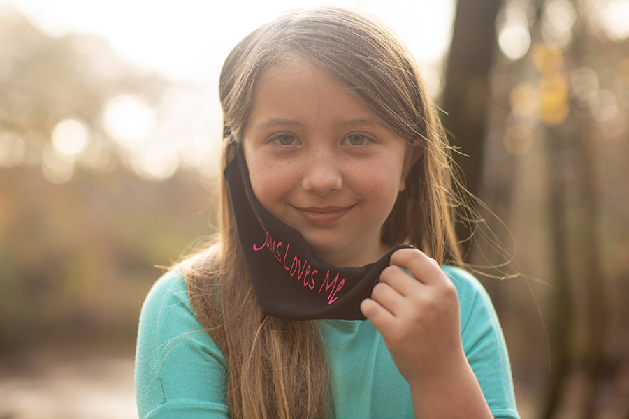 Lydia Booth smiles as holds her 'Jesus Loves Me